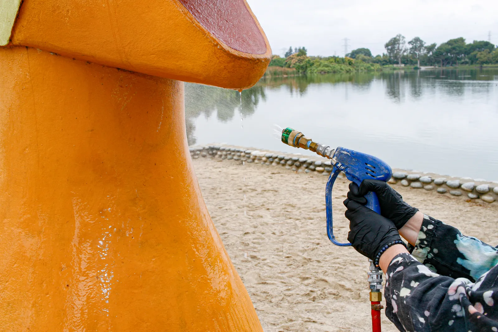 Jennifer applying solvent-based cleaning gel to remove graffiti on concrete sculpture