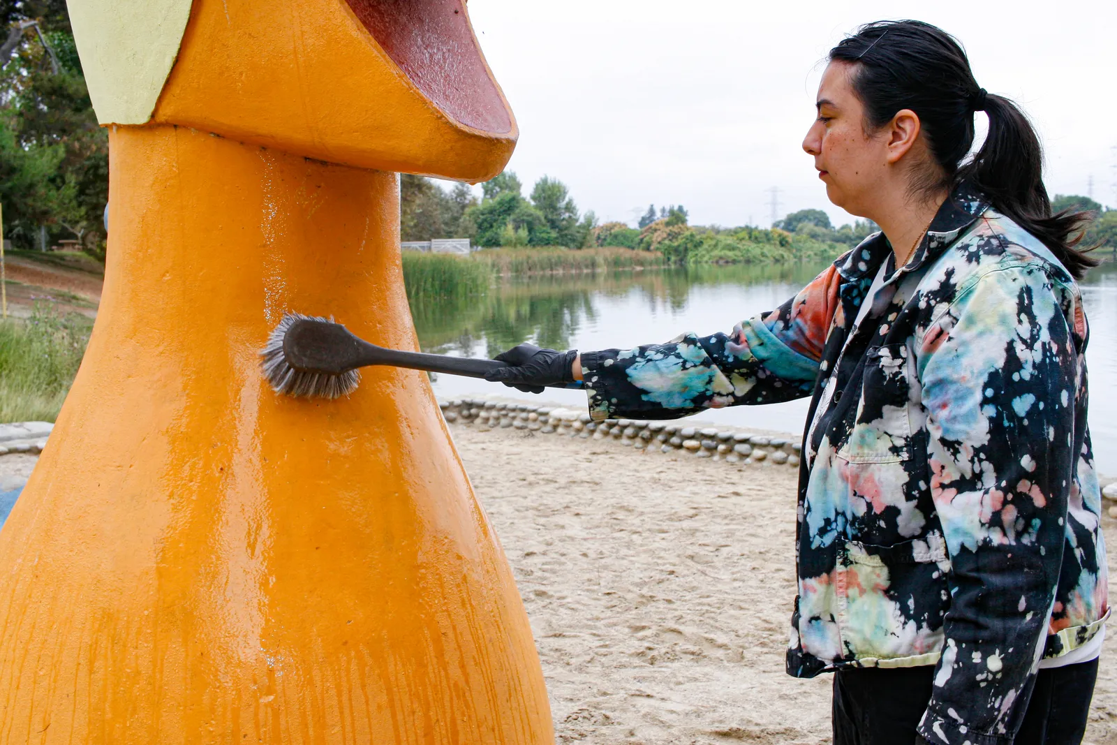 Jennifer applying chemical consolidant to weathered concrete sculpture surface