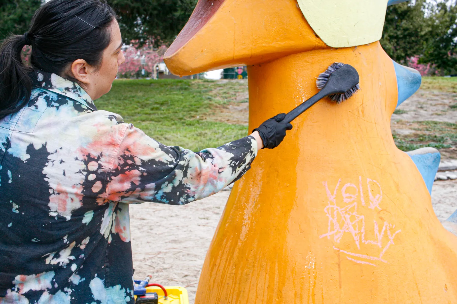 Jennifer applying a clear protective coat to the restored concrete sculpture
